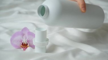 Doğal eko jel sıvı çamaşır deterjanı şişeden kapağa dökülüyor..