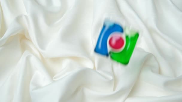 Laundry Pod Slowly Falling Satin Fabric Slow Motion Top View — Stock Video
