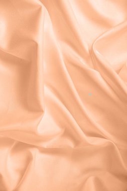 Dalgalar ve buruşuk doğal saten kumaş desenleri. 2024 Peach Fuzz Yılı Rengi.