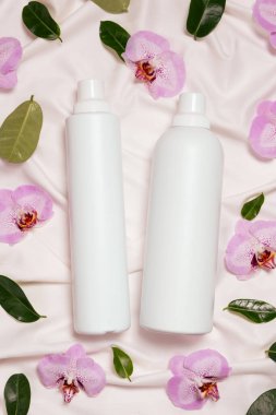 Sıvı çamaşır deterjanı ve yumuşatıcı yatak örtüsü, orkide çiçekleri, üst manzara..