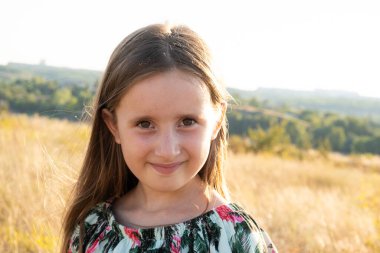 Doğada yazın tarlada yürüyen mutlu beş yaşındaki bir kızın portresi.