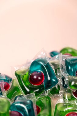 Bej arka planda çamaşır kapsülleri, metin için yer.