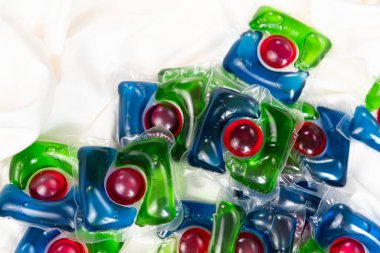 Saten kumaşta bir sürü çamaşır kapsülü var.