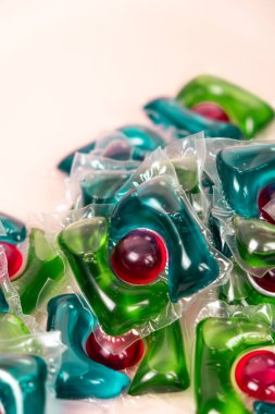 Bej arka planda çamaşır kapsülleri yakın plan.