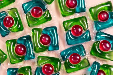 Bej arka planda çamaşır kapsülleri yakın plan.