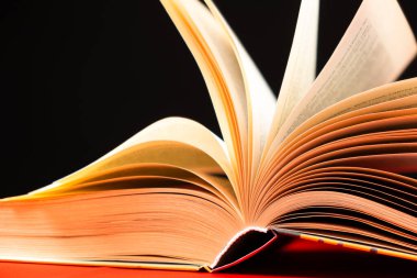 Kalın bir kitabın sayfaları siyah bir arkaplanda açılır.