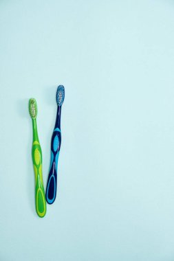 Mavi arkaplanda iki diş fırçası, üst görünüm, metin için boşluk