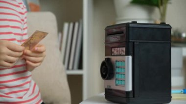 6 yaşında bir çocuk oyuncak kasasına koyarak para biriktiriyor. Finansal açıdan bilgili çocuklar..