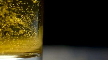Siyah arka plan makro ağır çekimde bira bardağındaki kabarcıklar