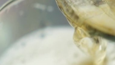 Bir bardağa, köpüğe ve köpüğe bira dökerken makro yavaş çekim.