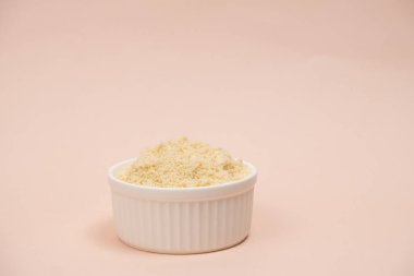 Bej arkaplanda bir tabakta badem unu, metin için yer.