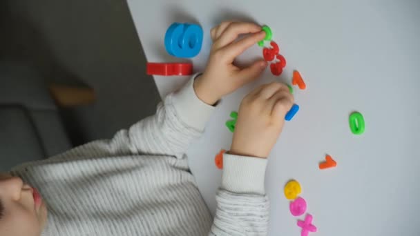 一个六岁的孩子通过玩数字来学习数学 并把数字合成数学例子 — 图库视频影像