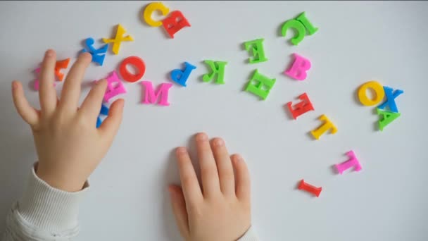 学龄前儿童或小学生从桌上的信件中拼凑出一个单词回家 — 图库视频影像