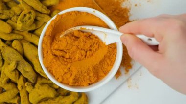 Şef zerdeçal tozu gösteriyor, kaşık, üst görüş, yavaş çekim..