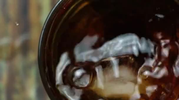 Lód Wpada Szklanki Koniaku Rozpryskując Alkohol Widok Góry Zwolniony Ruch — Wideo stockowe