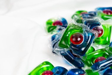 Bir sürü çamaşır kapsülü kapsülü saten kumaş üzerine deterjan, metin için boşluk kopyala