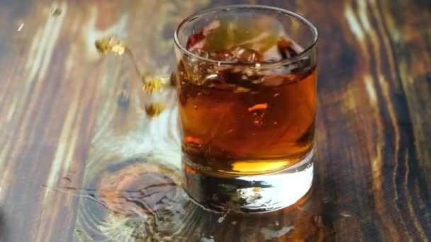 Ijs Valt Een Glas Cognac Spetterende Alcohol Bovenaanzicht Slow Motion — Stockvideo