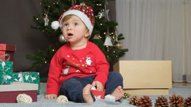 Portret Miesięcznego Dziecka Kapeluszu Mikołaja Bawiącego Się Zabawkami Świątecznymi — Wideo stockowe
