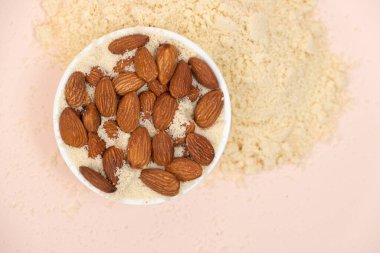 Pembe arka plan görünümlü badem unu ve badem..