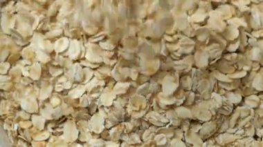 Kuru yulaf ezmesi tabağa dökülüyor, üst görünüm makro yavaş çekim