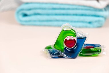 Bej arka planda yumuşak havluları olan çamaşır kapsülleri