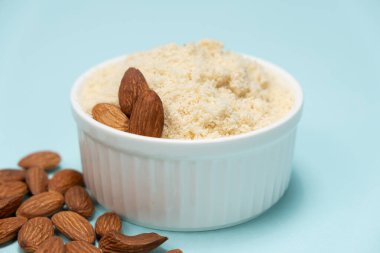 Açık mavi zemin üzerinde badem unu ve badem..