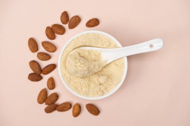 Pembe arka plan görünümlü badem unu ve badem..