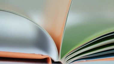 Çok renkli sayfaları olan bir kitabın sayfalarını çevirmek, yavaş çekim