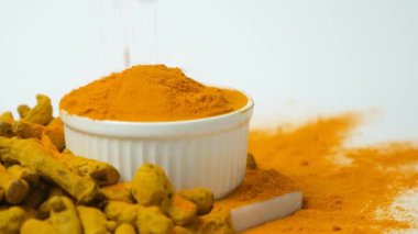 Zerdeçal tozu plaka kenarından yavaş çekim makrosu içine dökülüyor