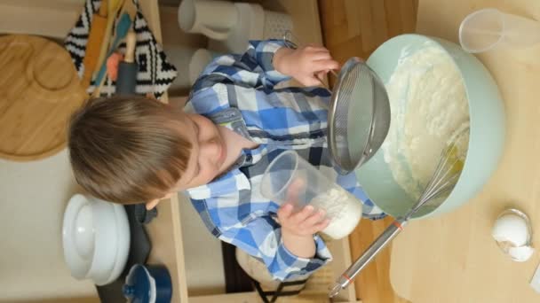 小麦粉をふるう子供 キッチンでクッキー生地を作る 垂直遅い動き — ストック動画