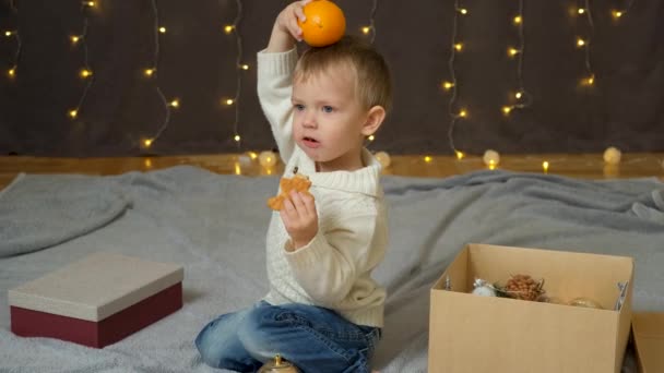 Porträtt Liten Pojke Som Äter Pepparkakor Och Leker Med Apelsiner — Stockvideo