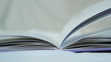 Yatakta kitap boyunca rüzgar yaprağı, yavaş çekim..