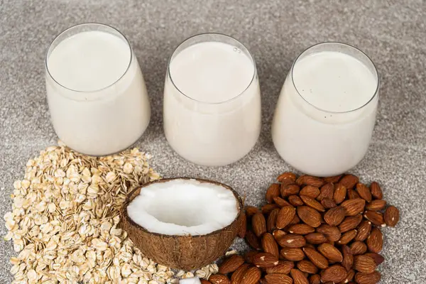 Types of plant-based milk in glasses. Oat, coconut and almond milk