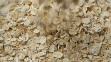 Kuru yulaf ezmesi tabağa dökülüyor, üst görünüm makro yavaş çekim