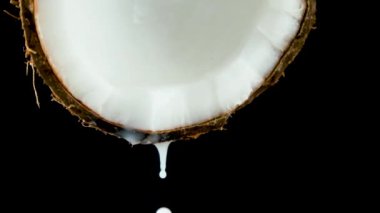 Hindistan cevizi suyu yavaş çekimde Hindistan cevizinin yarısından damlıyor.