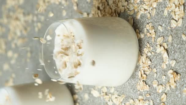 Βρώμη Που Πέφτει Ένα Ποτήρι Βρώμης Υγιές Γάλα Κάθετη Αργή — Αρχείο Βίντεο