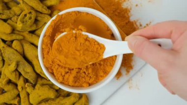 Şef zerdeçal tozu gösteriyor, kaşık, üst görüş, yavaş çekim..