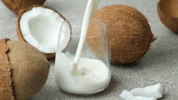 ココナッツミルクはココナッツの間にガラスに注ぎ ゆっくりとした動き — ストック動画