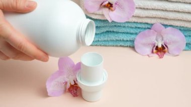 Doğal eko jel sıvı çamaşır deterjanı şişeden kapağa dökülüyor..