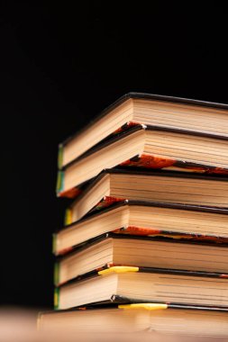 Siyah arka planda bir yığın eski kitap. Bilgelik ve bilgi, okuma aşkı.