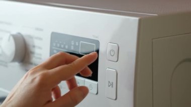 Çamaşır makinesinin başlatma tuşuna basıyorum..