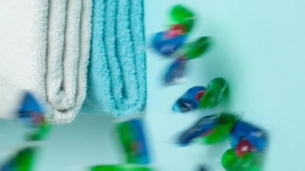 Kapsułki Pralnicze Wylewane Niebieskie Tło Czystymi Miękkimi Ręcznikami Pęd Pionowy — Wideo stockowe