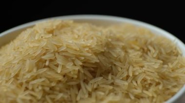 Siyah zemin üzerinde dönen uzun buğday haşlanmış basmati pilavı..