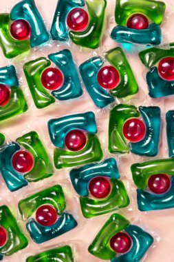 Bej arka planda çamaşır kapsülleri yakın plan.