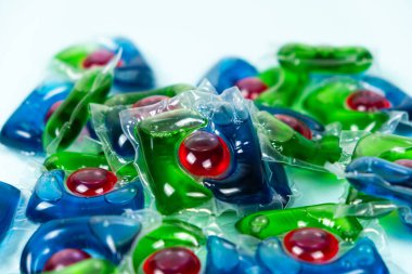 Mavi arkaplandaki çamaşır kapsülleri yakın plan.