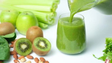 Yeşil kereviz, kivi, yeşil elma ve ıspanak kadehe dökülüyor, ağır çekimde.