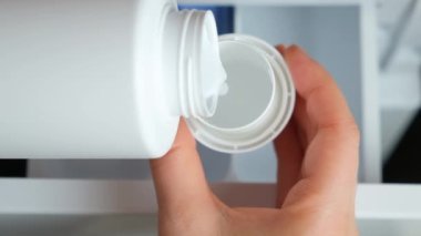 Çamaşır makinesinin arka planına yumuşatıcı dökme işlemi