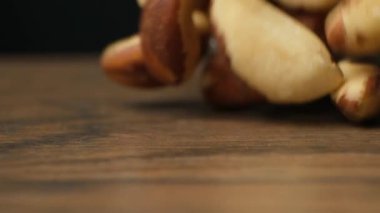 Kahverengi arka planda ağır çekimde düşen makro Brezilya fındıkları.