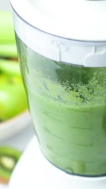 Karıştırıcıda sebze kokteyli pişirmek, bileşenleri öğütme sürecinin dikey yavaş çekimi.