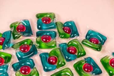 Bej arka planda çamaşır kapsülleri yakın plan.